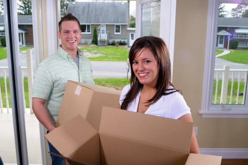 Professional office movers handling desks, files, and equipment for a Holland Park business move
